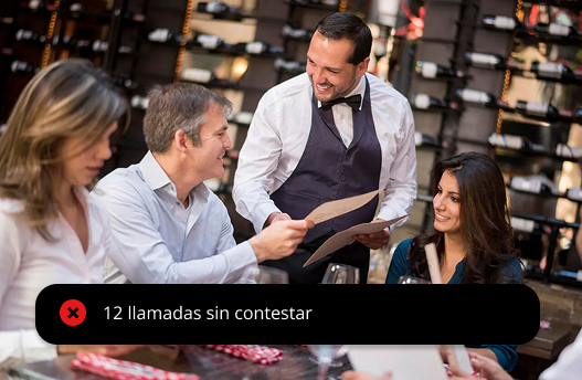 Camarero atendiendo a clientes mientras suena el teléfono en el restaurante