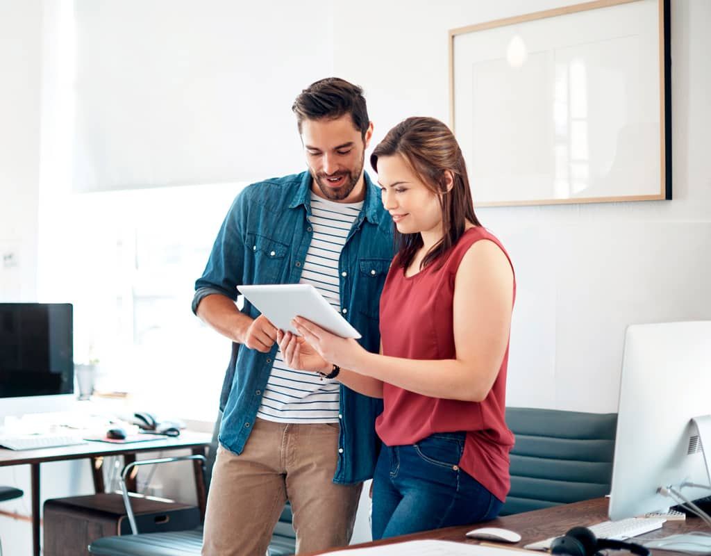 Compañeros de trabajo comprueban en su tablet la copia de seguridad de su correo