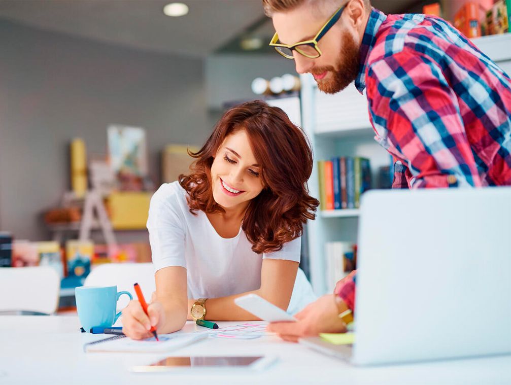 En una oficina dos compañeros trabajan en su próximo proyecto con la tranquilidad de tener una copia de seguridad de su web