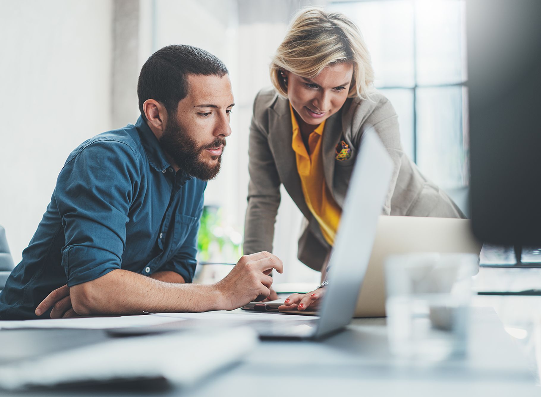 Compañeros de trabajo buscando dominios baratos en su portátil