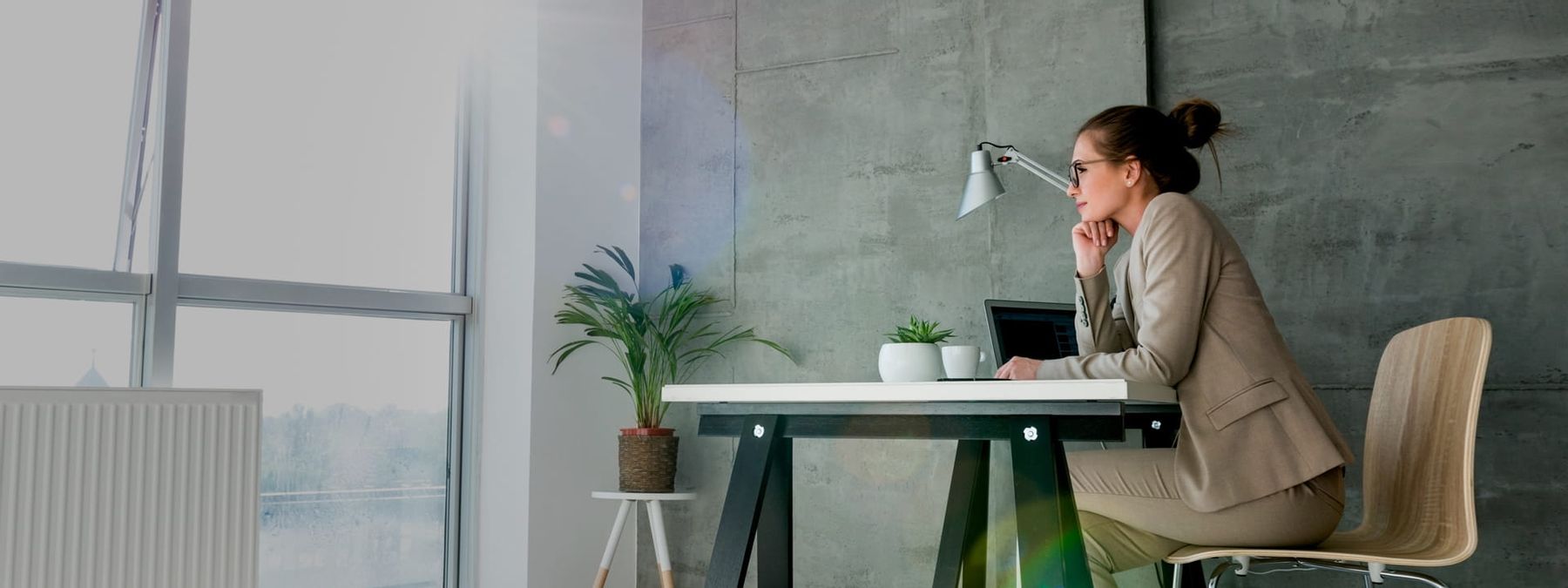 Chica reflexiona delante de un ordenador posilbles nombres nombres de dominios .com para su proyecto