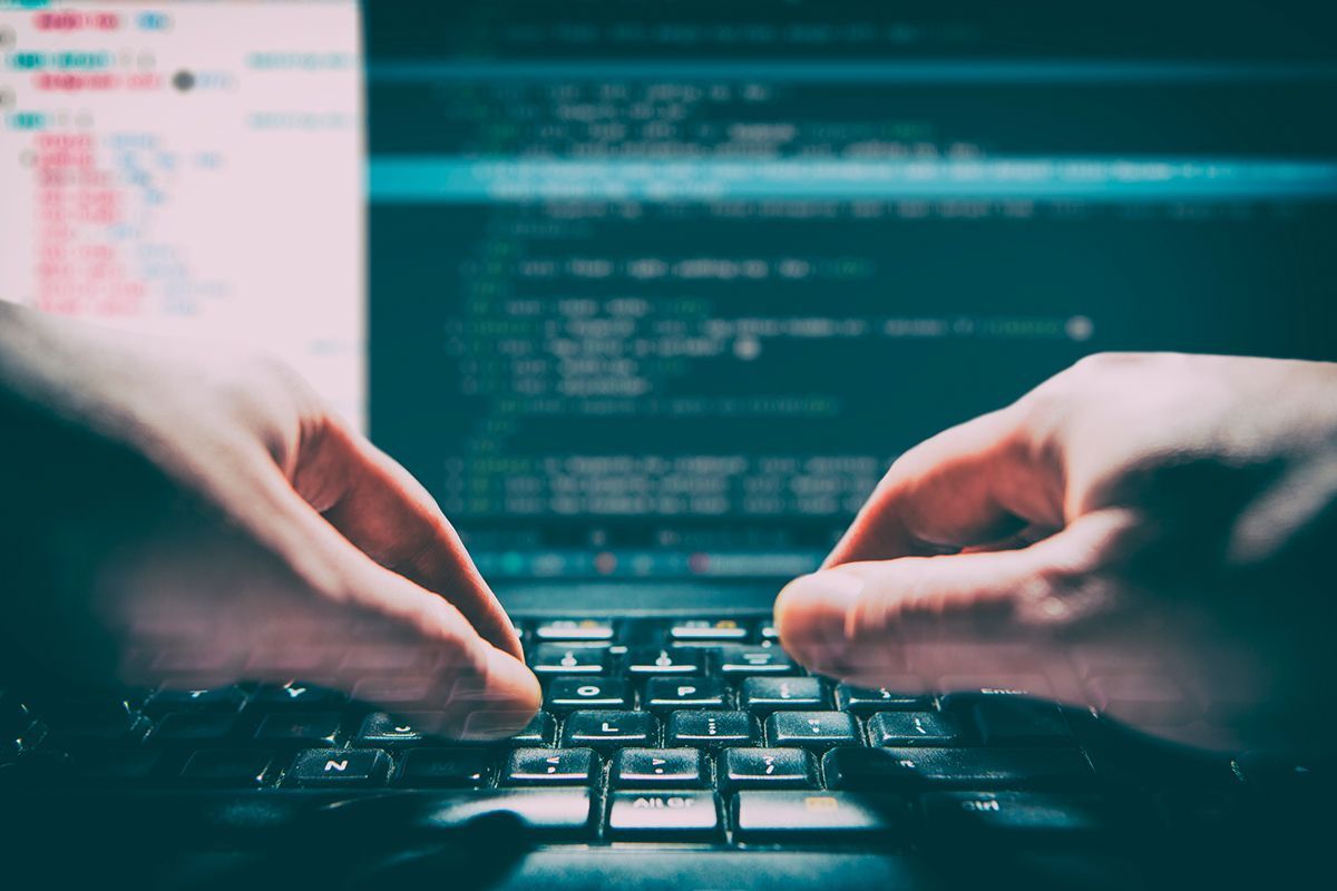 Manos escribiendo código en un ordenador, representando desarrollo web con dominios .dev