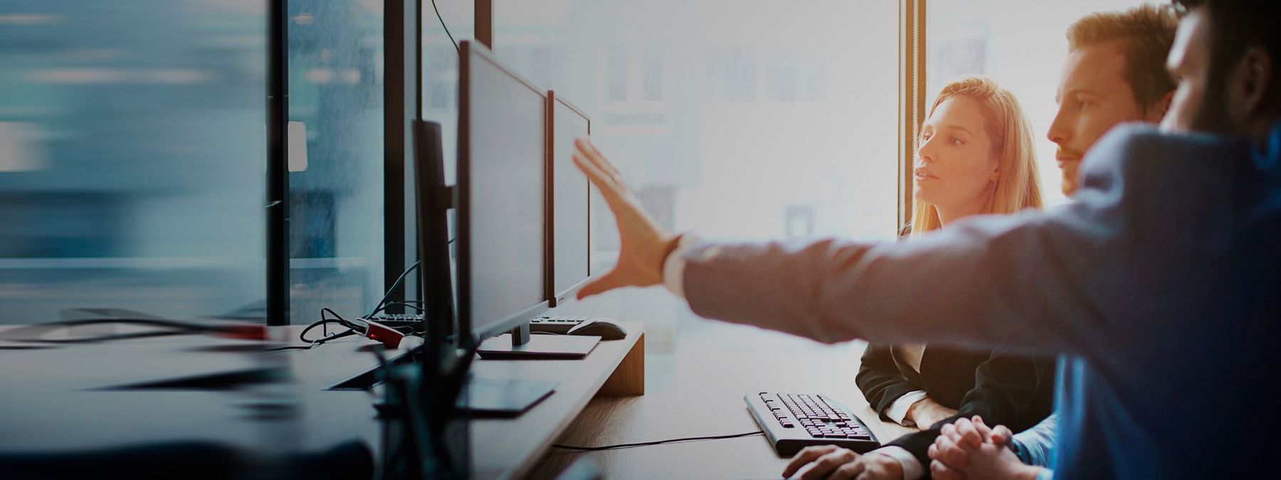 Equipo de desarrolladores mirando pantallas de ordenadores para registrar un dominio .dev para su proyecto