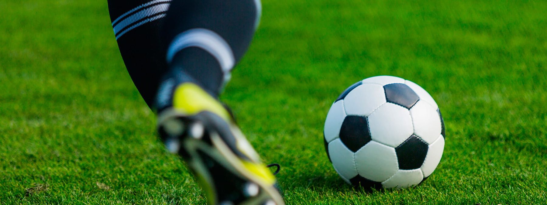 Pies de un jugador de fútbol en acción, destacando la pasión del deporte con dominios .futbol