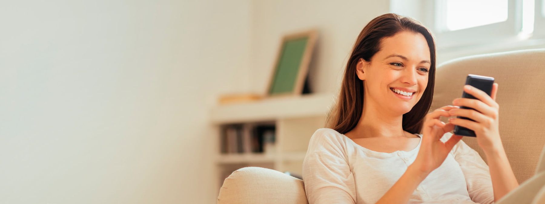 Chica consultando su móvil para registrar un dominio .mobi