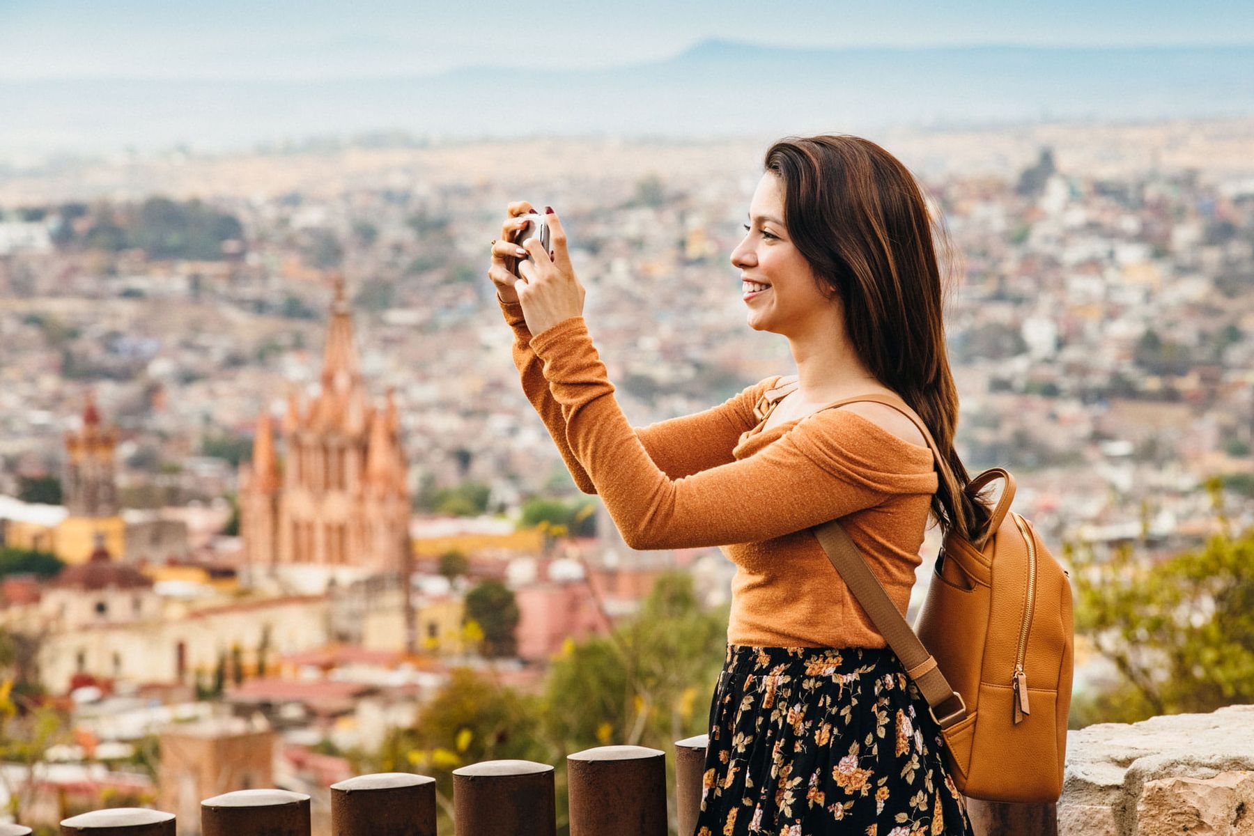 Chica fotografiando una ciudad de México, simbolizando la cultura y presencia digital con dominios .commx