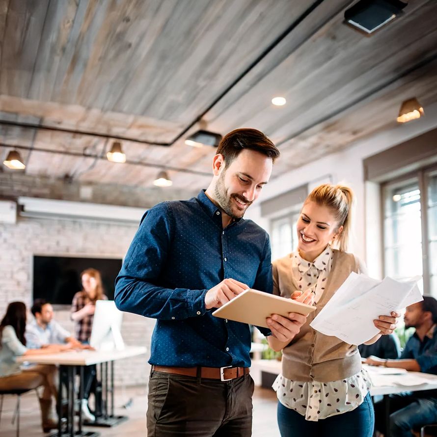 Grupo de trabajando donde dos compañeros revisan un listado de dominios .site
