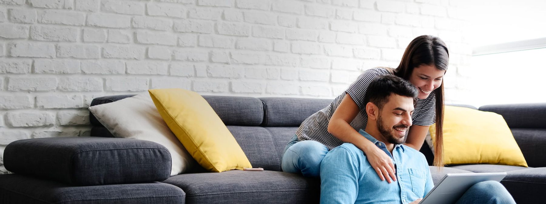 Una pareja consultando en su sofá qué nombres de dominios .tv pueden registrar