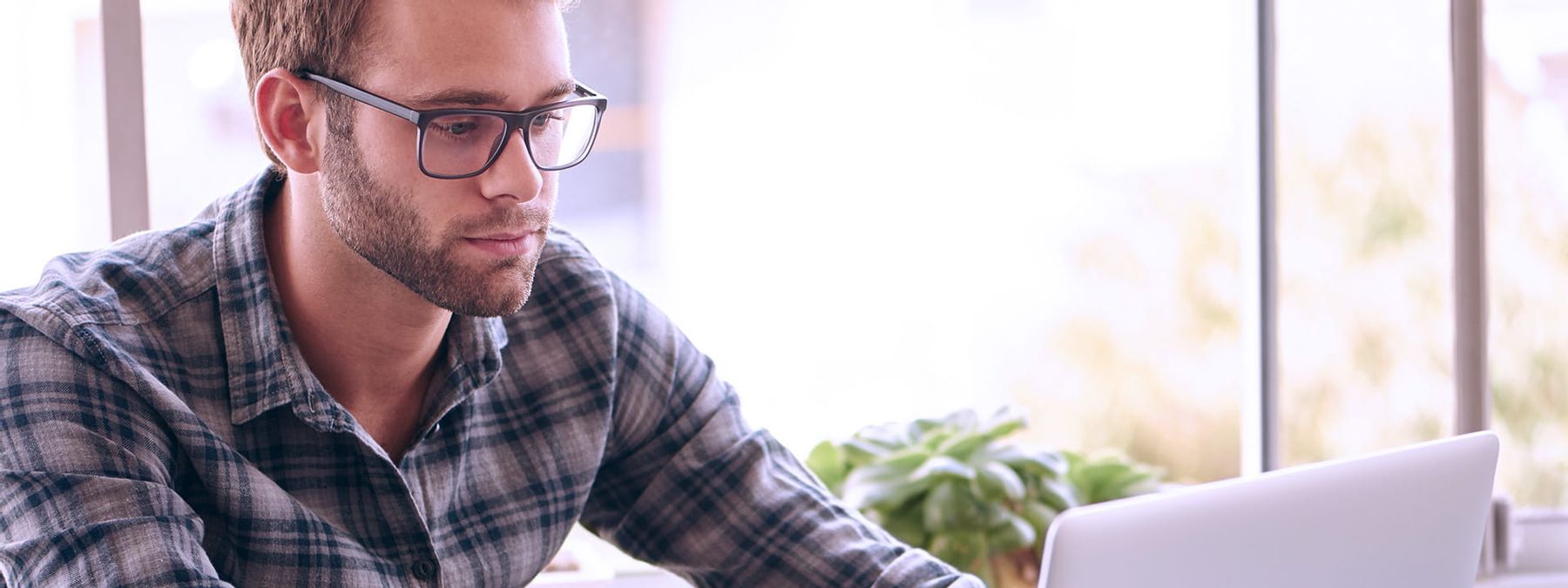 Chico consultando en su portátil los beneficios de nuestro plan de reseller de Hosting