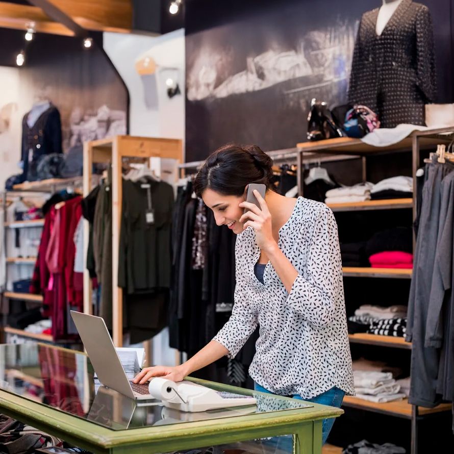 Dependienta de una tienda de ropa atendiendo una llamada de teléfono