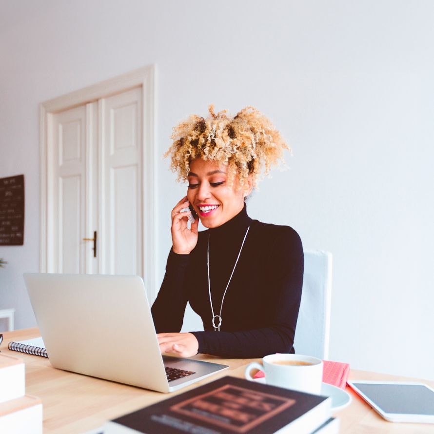 Chica consulta en su portátil cómo puede migrar su correo profesional a Arsys