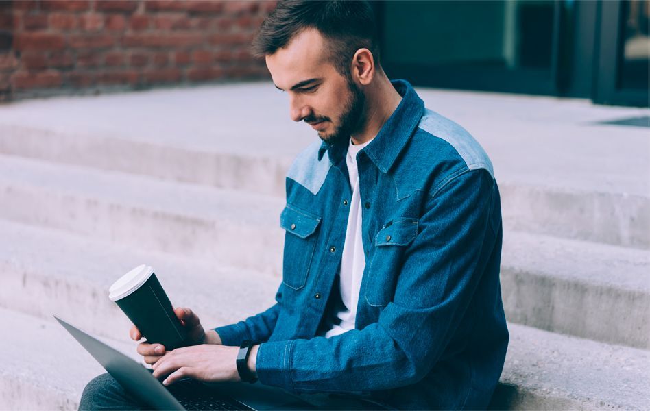 Chico consulta en su portátil cómo puede migrar su buzón de correo electrónico a Arsys