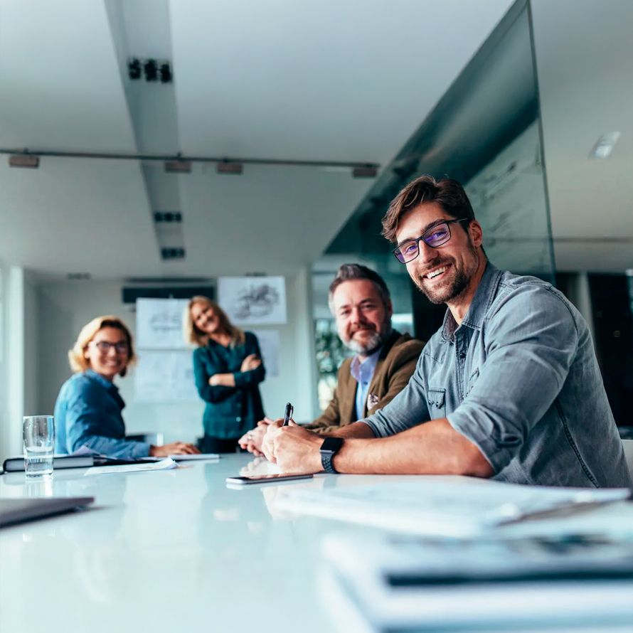 Reunión de trabajo donde todos sonríen porque trabajan en Arsys, una empresa con más de 25 años de experiencia
